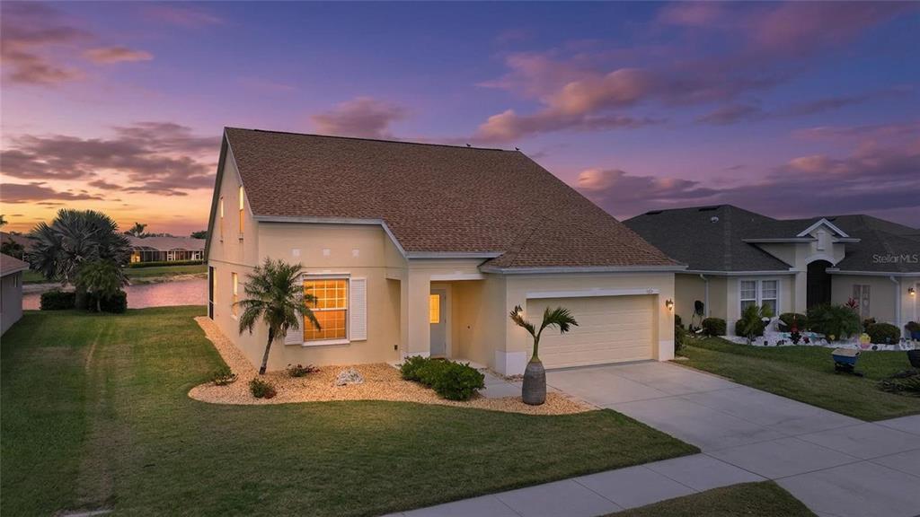 5221 Layton Drive Venice, FL 34293 - Photo 2 of 33 a front view of a house with a yard and garage