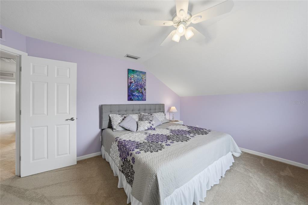 5221 Layton Drive Venice, FL 34293 - Photo 22 of 33 a bedroom with a large bed and a chandelier