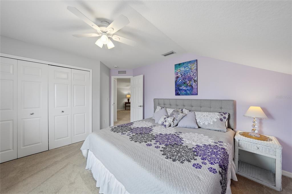 5221 Layton Drive Venice, FL 34293 - Photo 23 of 33 a bedroom with a large bed and a chandelier