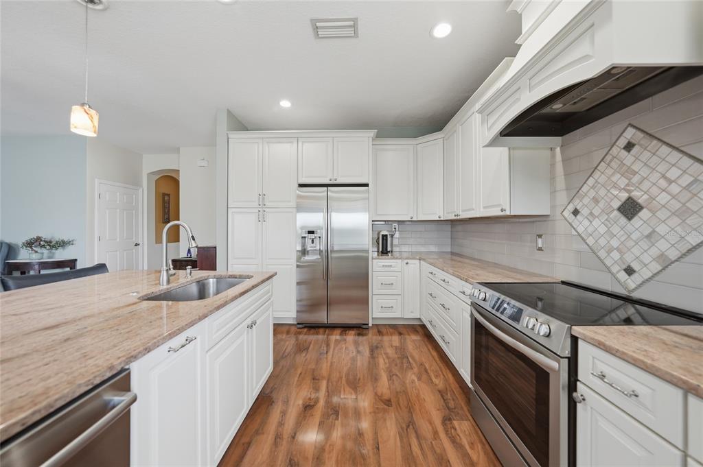 5221 Layton Drive Venice, FL 34293 - Photo 3 of 33 a kitchen with stainless steel appliances granite countertop a sink stove and refrigerator