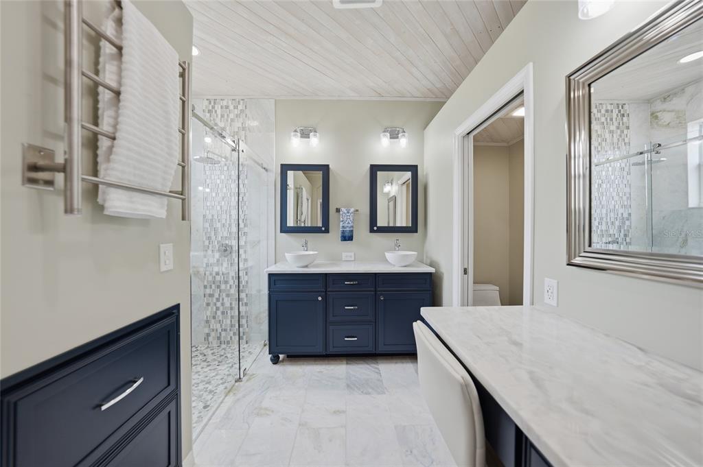 5221 Layton Drive Venice, FL 34293 - Photo 4 of 33 a spacious bathroom with a granite countertop sink mirror and a bathtub
