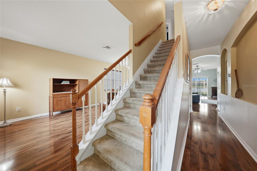 5221 Layton Drive Venice, FL 34293 - Photo 7 of 33 a view of staircase with lots of frames on wall and wooden floor