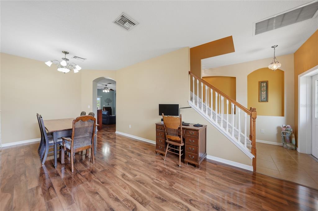 5221 Layton Drive Venice, FL 34293 - Photo 8 of 33 a view of a dining room with furniture and wooden floor