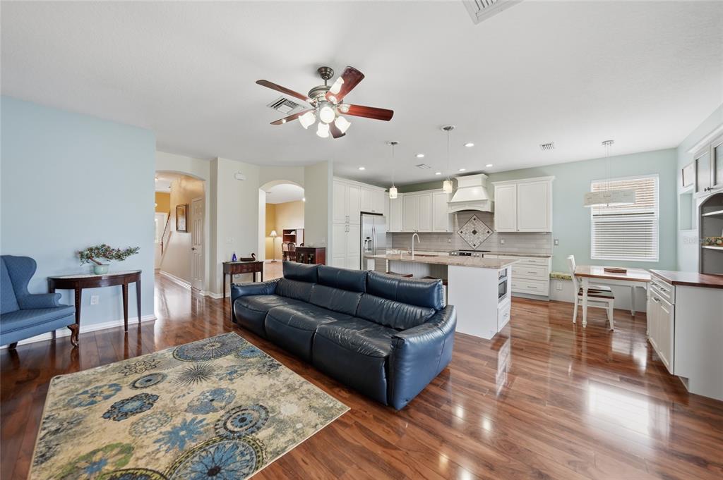 5221 Layton Drive Venice, FL 34293 - Photo 9 of 33 a living room with furniture wooden floor and a kitchen view