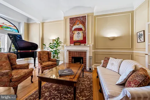 a dining room with furniture a chandelier and wooden floor