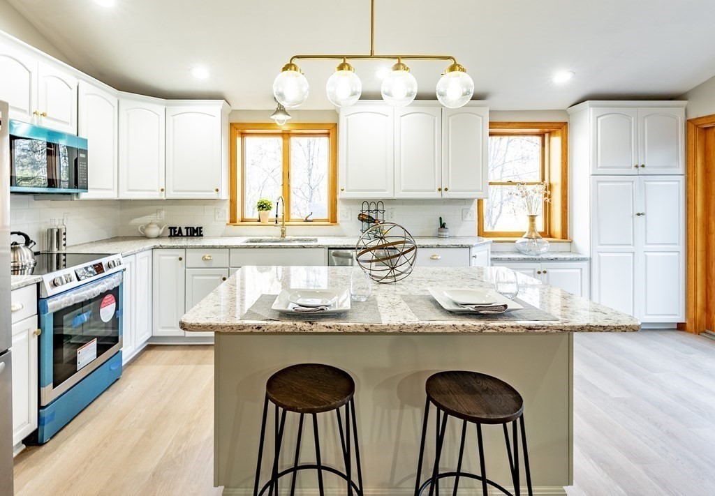 209 Freeman Road Charlton, MA 01507 - Photo 10 of 30 a kitchen with stainless steel appliances granite countertop a sink a stove a microwave a center island and cabinets