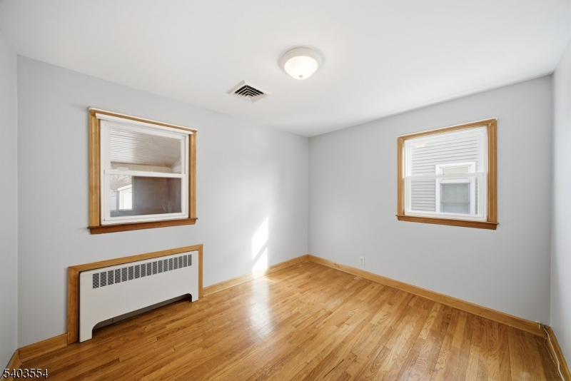 52 Broadway Clark, NJ 07066 - Photo 14 of 47 a view of an empty room with wooden floor and a window