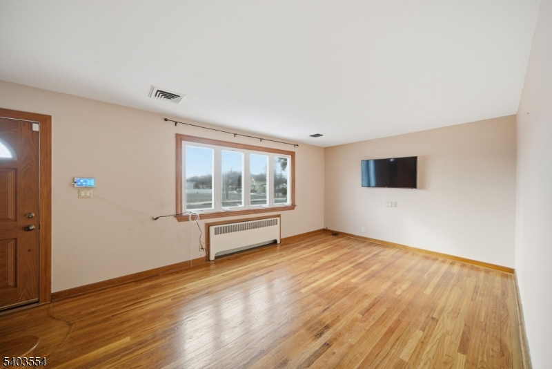 52 Broadway Clark, NJ 07066 - Photo 3 of 47 a view of an empty room with wooden floor and a window
