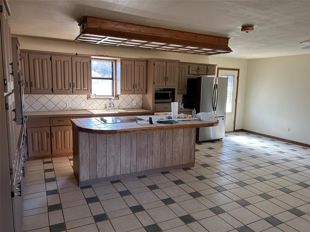 770 Rains County Road 3060 Emory, TX 75440 - Photo 27 of 39 a kitchen with kitchen island granite countertop a sink and a stove