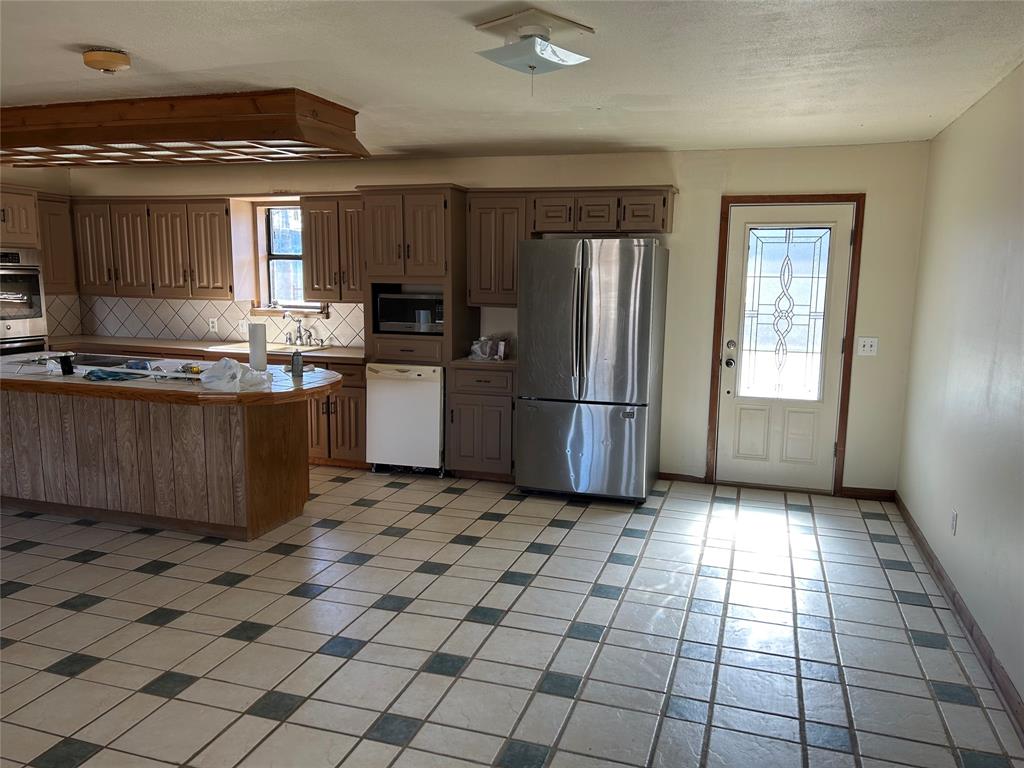 770 Rains County Road 3060 Emory, TX 75440 - Photo 28 of 39 a kitchen with stainless steel appliances granite countertop a refrigerator and a stove top oven
