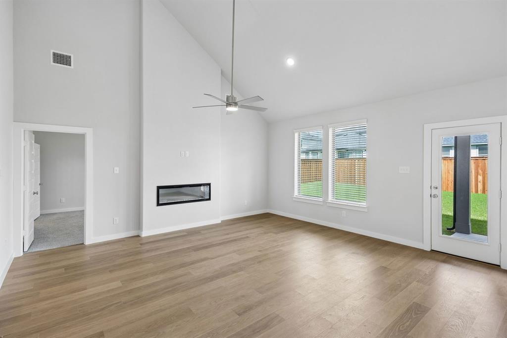 1469 Companero Street Haslet, TX 76052 - Photo 13 of 36 an empty room with wooden floor cabinet and windows