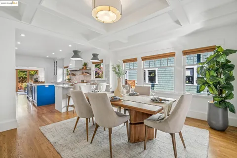 a dining room with furniture potted plants and wooden floor