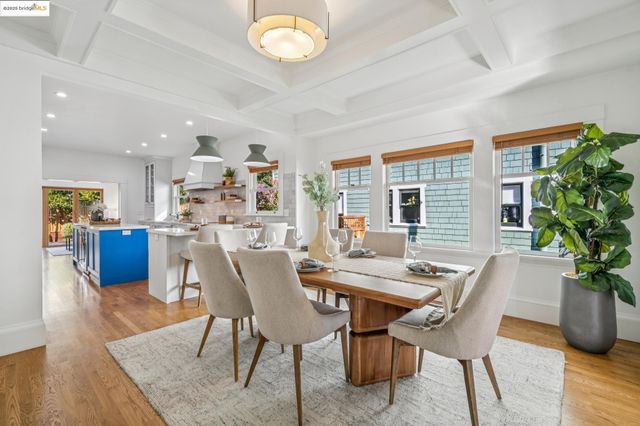 a dining room with furniture potted plants and wooden floor