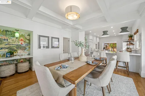 a view of a dining room with furniture a rug and wooden floor