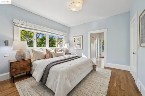 a bedroom with a bed and large windows