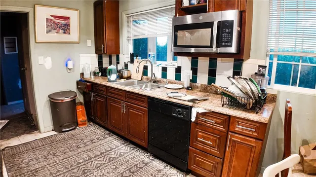 a kitchen with stainless steel appliances granite countertop a sink and a stove