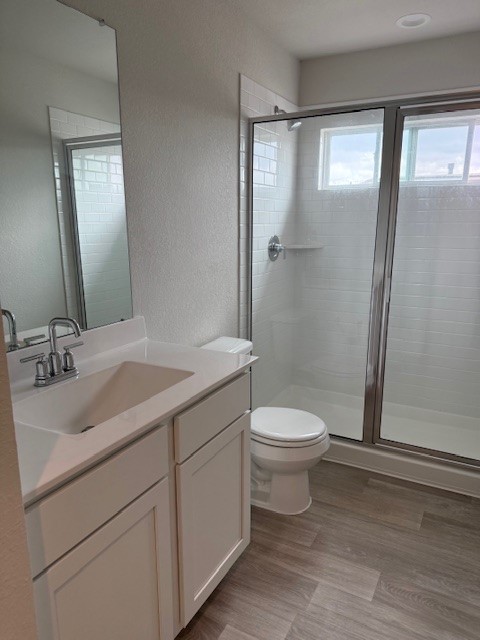 7838 Ruth Ravine Court Spring, TX 77379 - Photo 17 of 23 This modern bathroom features a sleek glass-enclosed shower, a white vanity with ample storage, and a large mirror. The space is bright and clean with wood-look flooring.