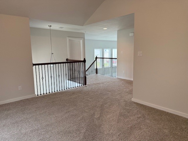 7838 Ruth Ravine Court Spring, TX 77379 - Photo 20 of 23 This photo shows a spacious, carpeted upstairs area with a neutral color palette. The space features a railing overlooking the lower level, allowing for a bright and open feel, and a hanging light fixture for added elegance.