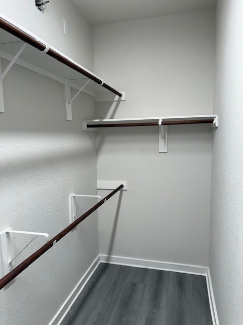 7838 Ruth Ravine Court Spring, TX 77379 - Photo 10 of 23 This is a small, walk-in closet featuring multiple wooden hanging rods and white brackets, with light gray walls and flooring. Ideal for organized clothing storage.