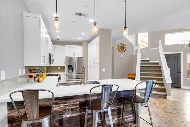 a kitchen with a table chairs microwave and cabinets