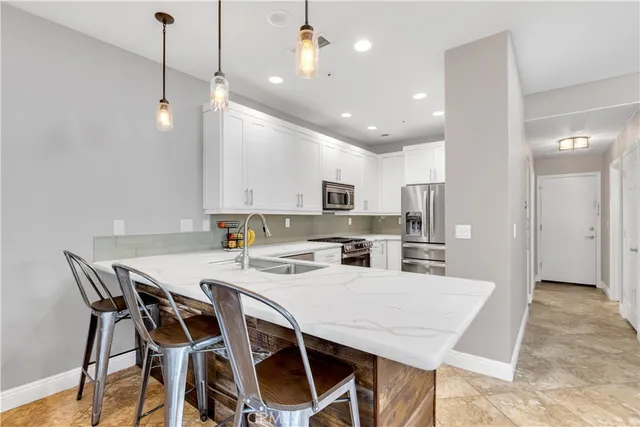 a kitchen with white cabinets stainless steel appliances and a counter space