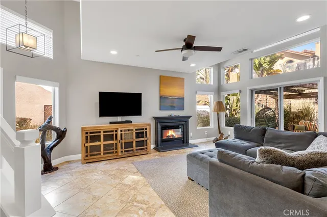 a living room with furniture and a flat screen tv with kitchen view