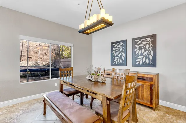 a kitchen with granite countertop a dining table chairs and white cabinets