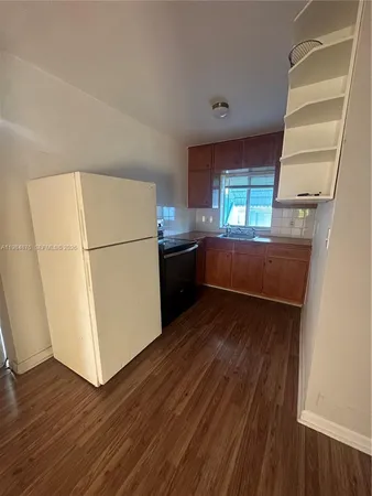a kitchen with a refrigerator and a stove top oven