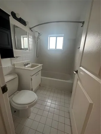 a bathroom with a toilet a sink a mirror a vanity and window
