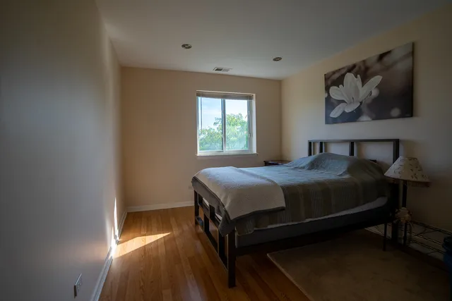 a bedroom with a bed and a painting on the wall