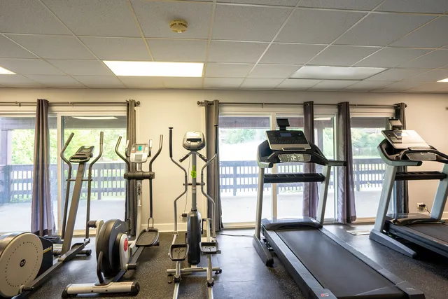 a room with gym equipment and large mirror