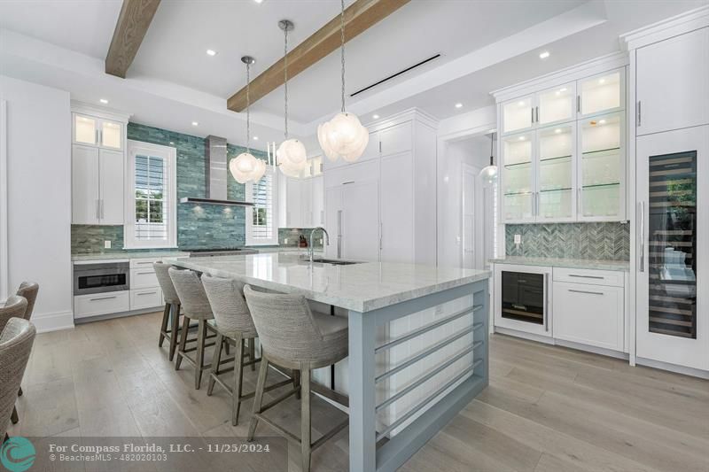 1122 Miramar Drive Delray Beach, FL 33483 - Photo 12 of 44 a kitchen with kitchen island granite countertop a stove a sink a dining table and chairs