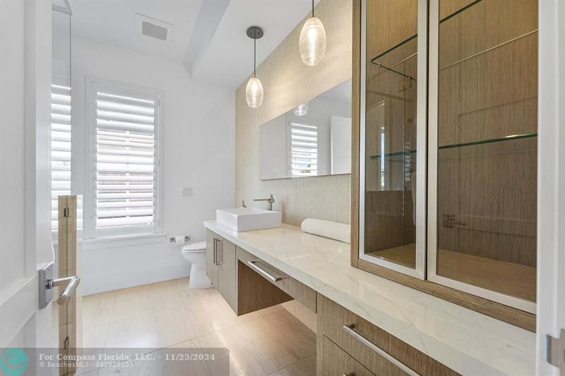 1122 Miramar Drive Delray Beach, FL 33483 - Photo 27 of 44 a bathroom with a granite countertop sink a toilet and shower
