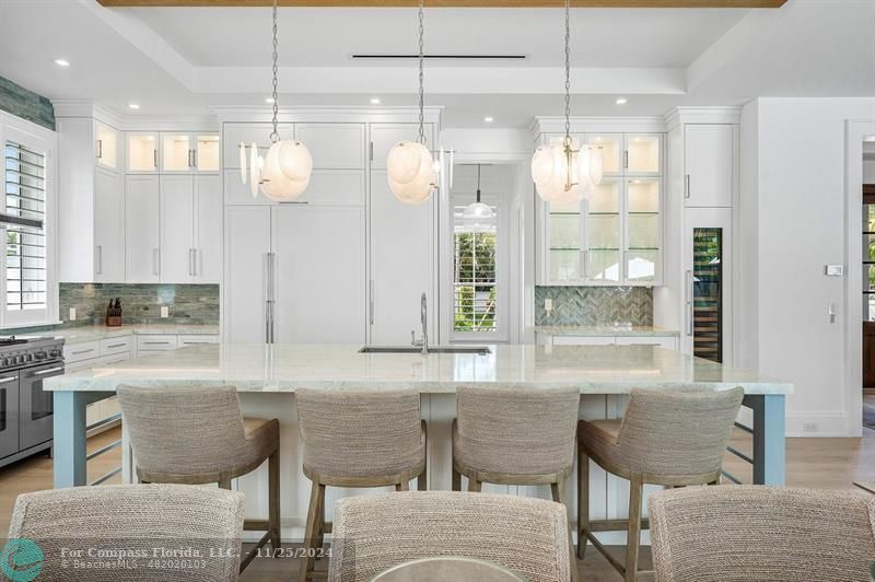 1122 Miramar Drive Delray Beach, FL 33483 - Photo 9 of 44 a kitchen with stainless steel appliances granite countertop a table chairs in it and wooden floors