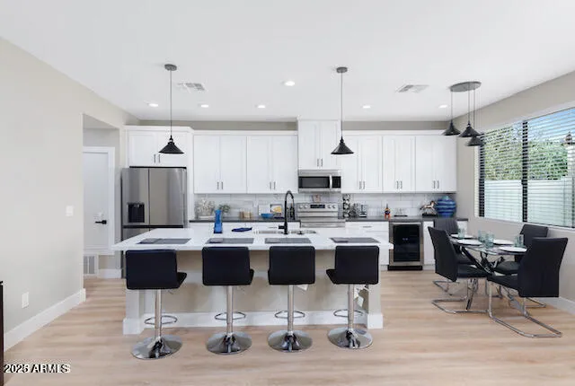 a kitchen with kitchen island stainless steel appliances a dining table and chairs