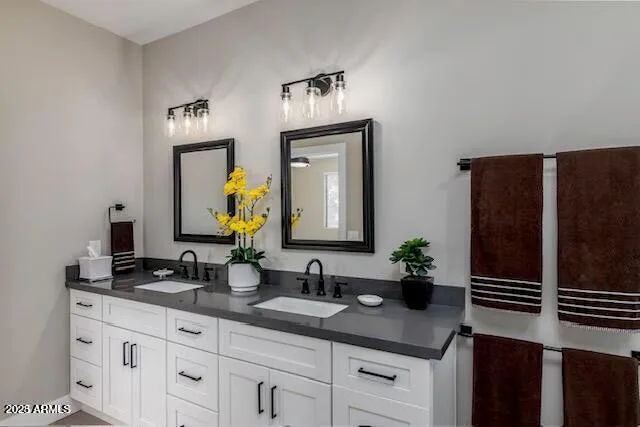 a bathroom with a granite countertop double sink and a mirror