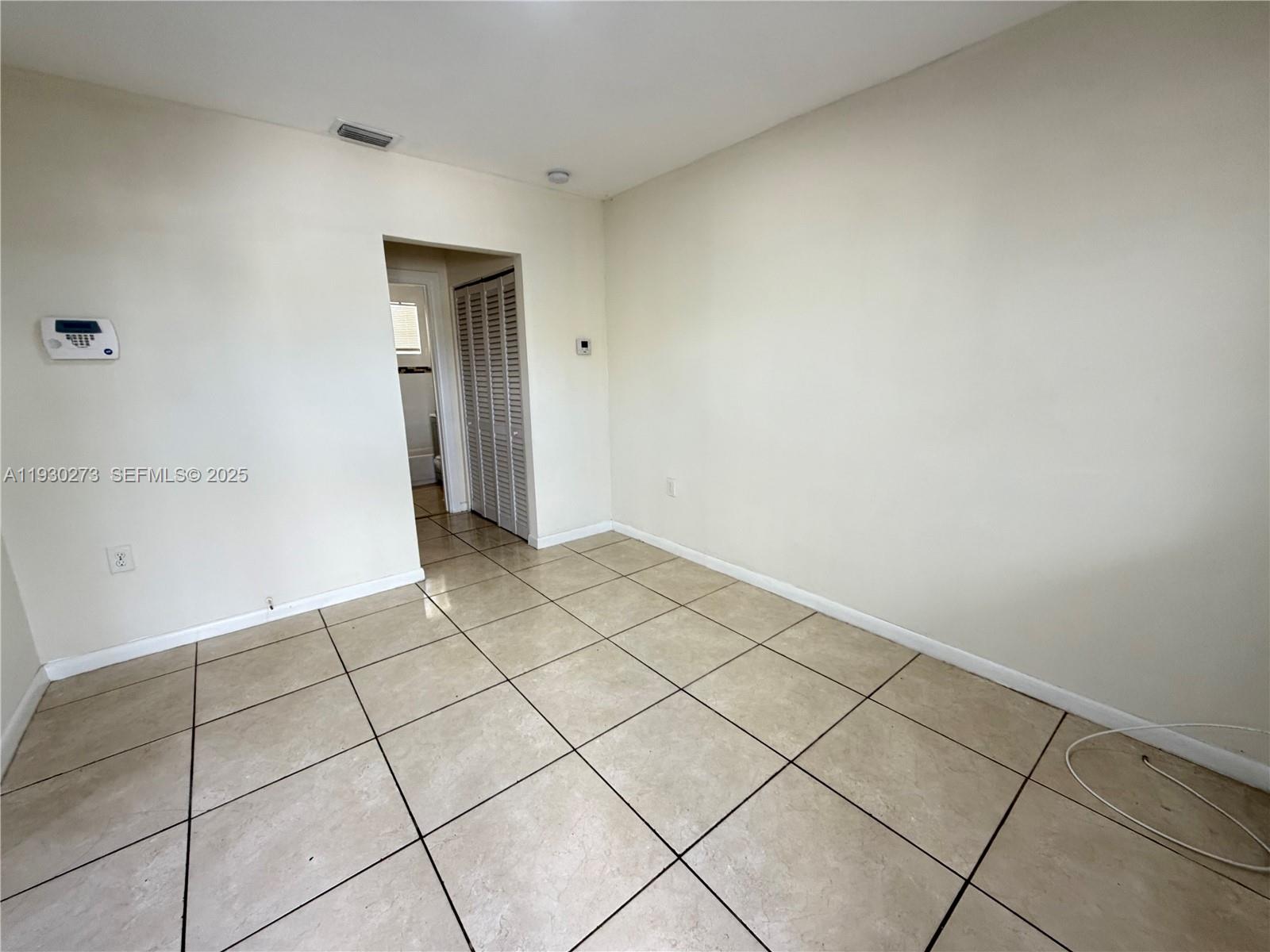 609 Northwest 7th Avenue, Unit 12 Hallandale Beach, FL 33009 - Photo 12 of 18 a view of an empty room and wooden floor