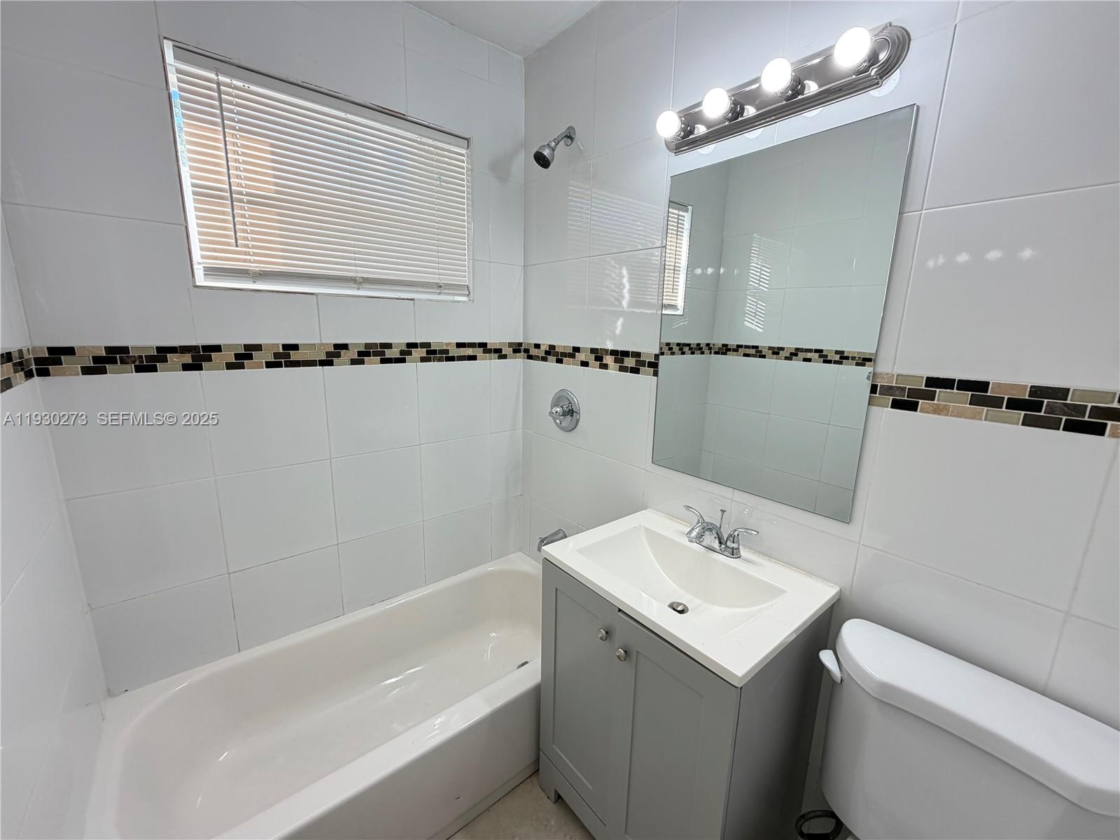 609 Northwest 7th Avenue, Unit 12 Hallandale Beach, FL 33009 - Photo 17 of 18 a bathroom with a sink a toilet and a bathtub