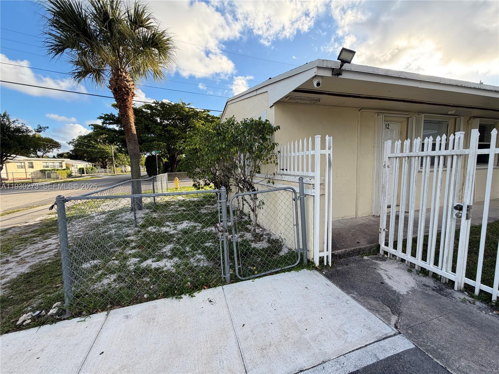 609 Northwest 7th Avenue, Unit 12 Hallandale Beach, FL 33009 - Photo 18 of 18 a view of a house with a tree in the yard