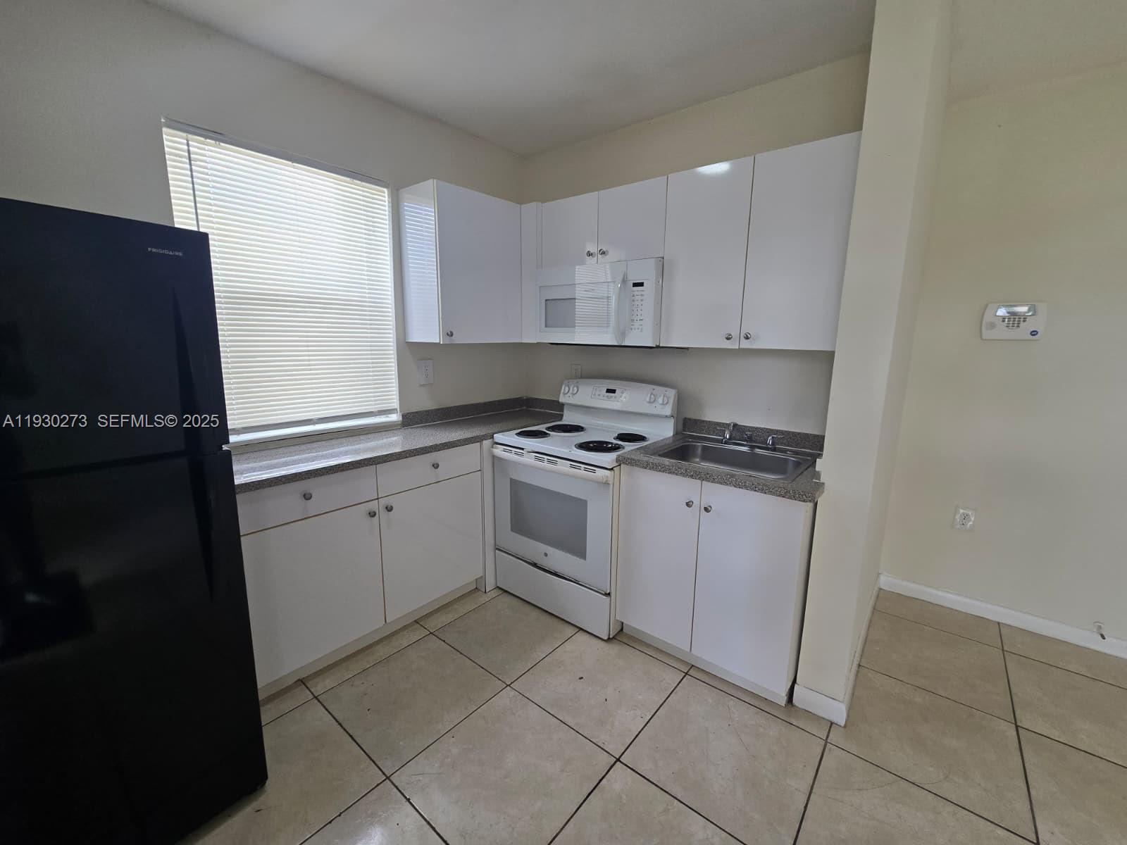 609 Northwest 7th Avenue, Unit 12 Hallandale Beach, FL 33009 - Photo 3 of 18 a kitchen with cabinets and appliances