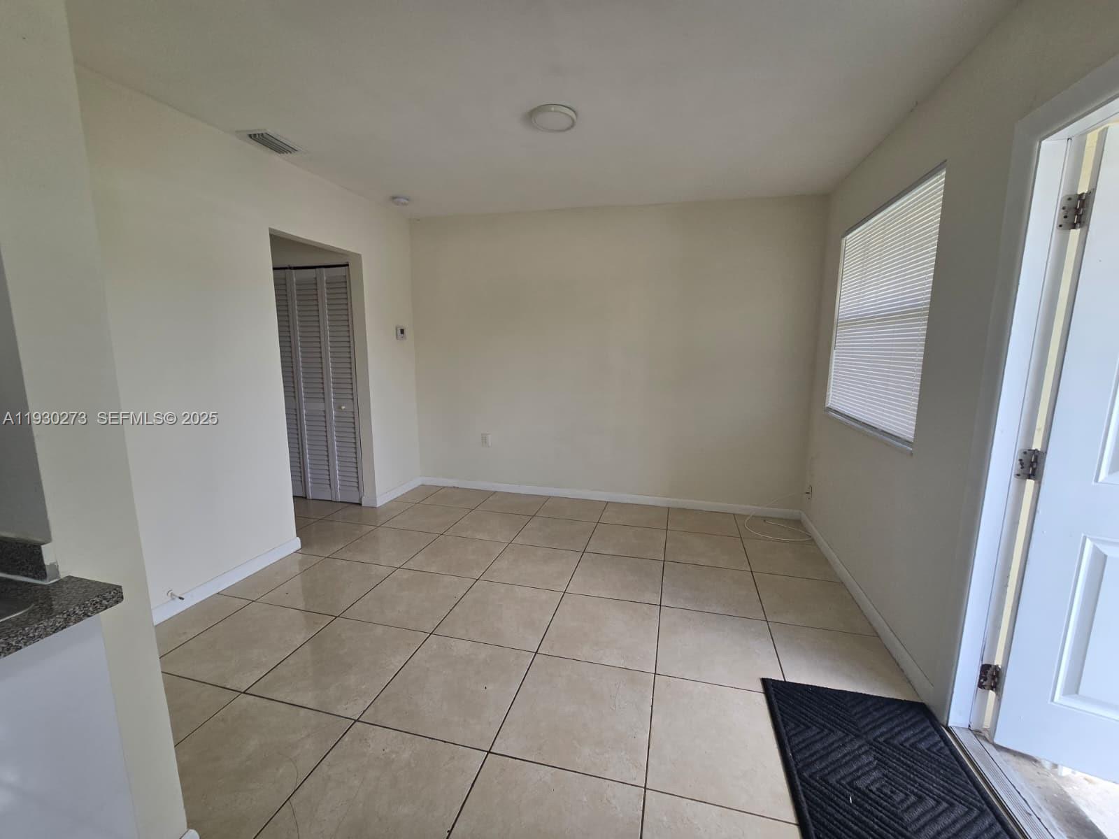 609 Northwest 7th Avenue, Unit 12 Hallandale Beach, FL 33009 - Photo 4 of 18 a view of an empty room and a window