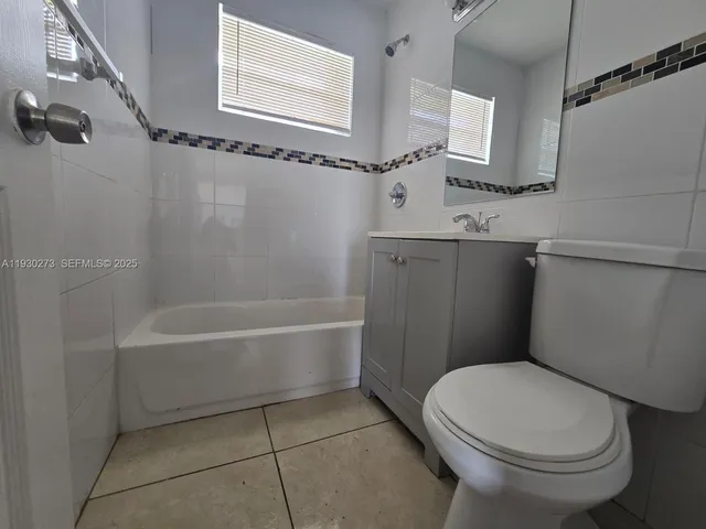 a white toilet sitting next to a bath tub