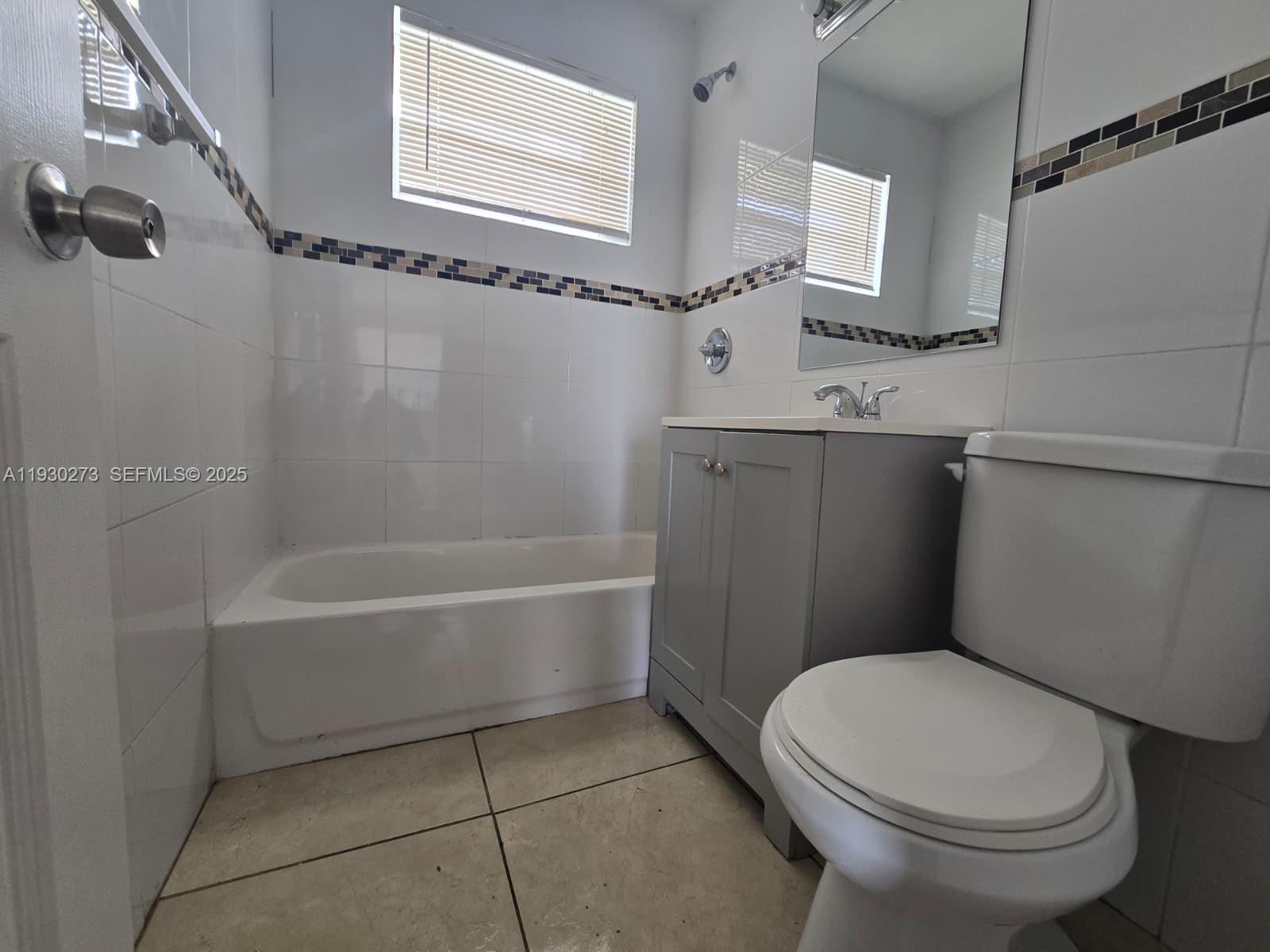 609 Northwest 7th Avenue, Unit 12 Hallandale Beach, FL 33009 - Photo 5 of 18 a white toilet sitting next to a bath tub