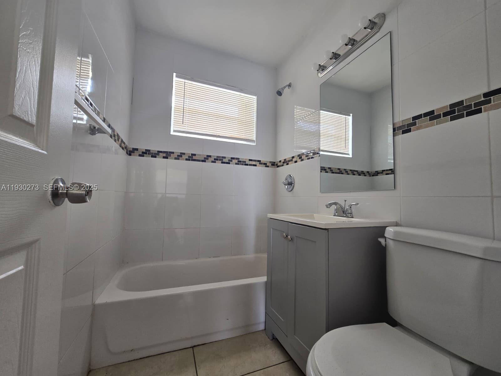 609 Northwest 7th Avenue, Unit 12 Hallandale Beach, FL 33009 - Photo 6 of 18 a bathroom with a sink a toilet and shower