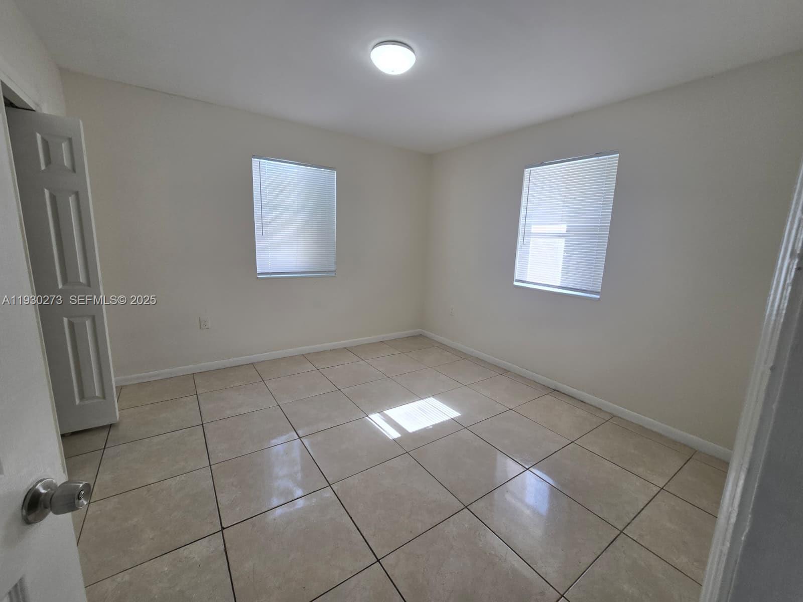 609 Northwest 7th Avenue, Unit 12 Hallandale Beach, FL 33009 - Photo 7 of 18 a view of an empty room with a window