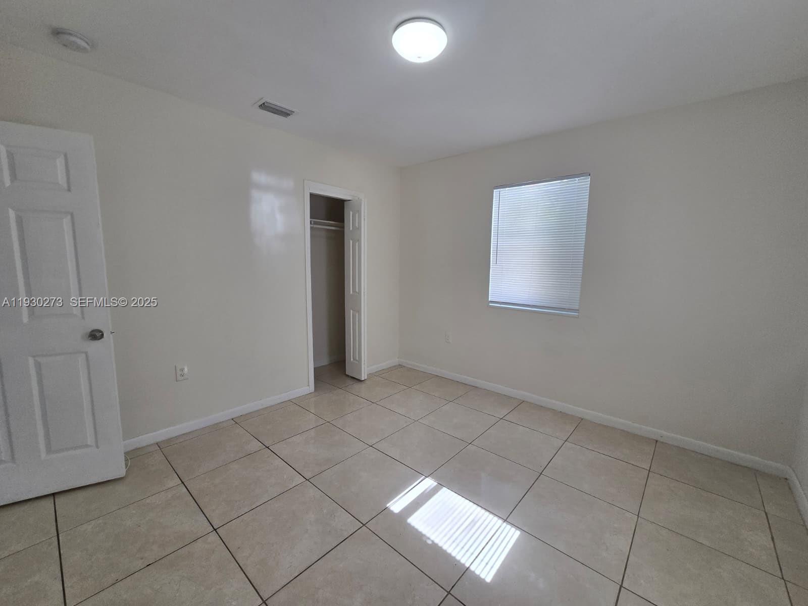 609 Northwest 7th Avenue, Unit 12 Hallandale Beach, FL 33009 - Photo 8 of 18 an empty room with windows