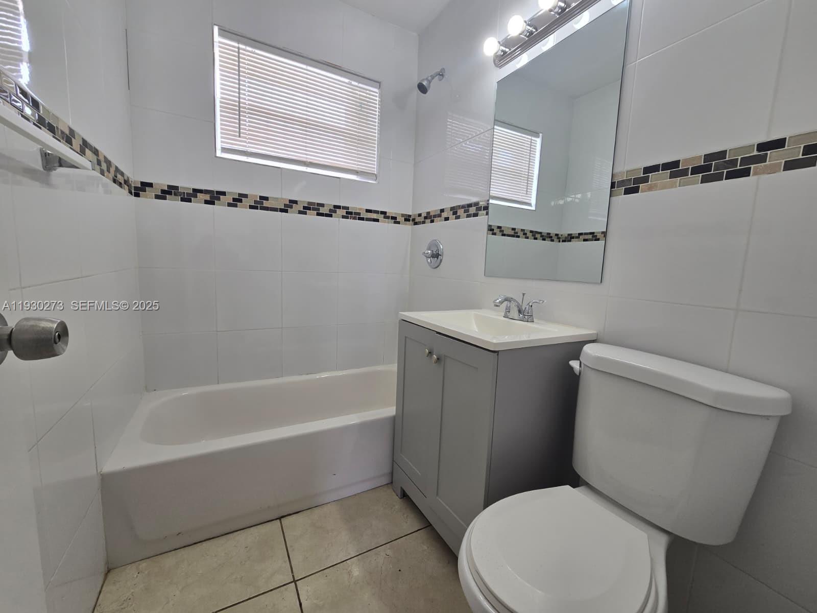 609 Northwest 7th Avenue, Unit 12 Hallandale Beach, FL 33009 - Photo 9 of 18 a bathroom with a sink a toilet and shower