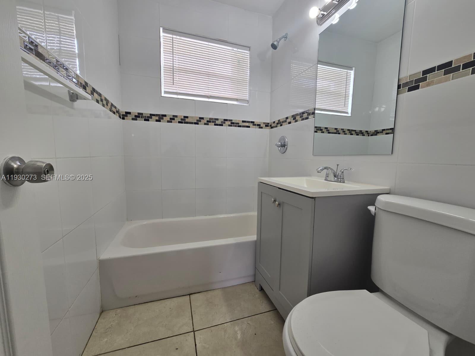 609 Northwest 7th Avenue, Unit 12 Hallandale Beach, FL 33009 - Photo 10 of 18 a bathroom with a sink a toilet and shower