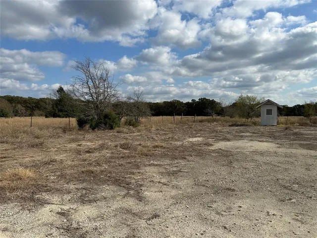 a view of a dry yard with wooden fence