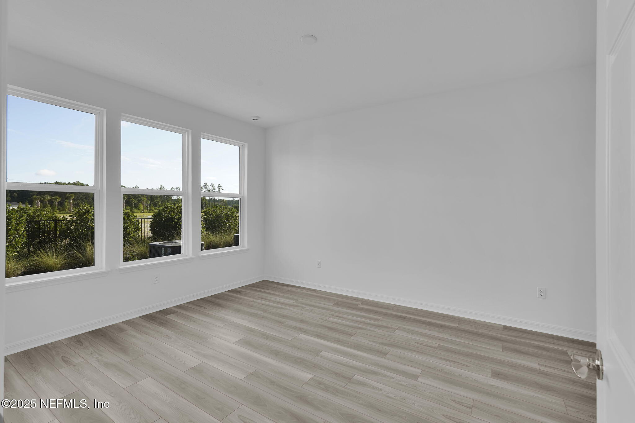 269 Ecliptic Loop Yulee, FL 32097 - Photo 16 of 44 an empty room with wooden floor and windows